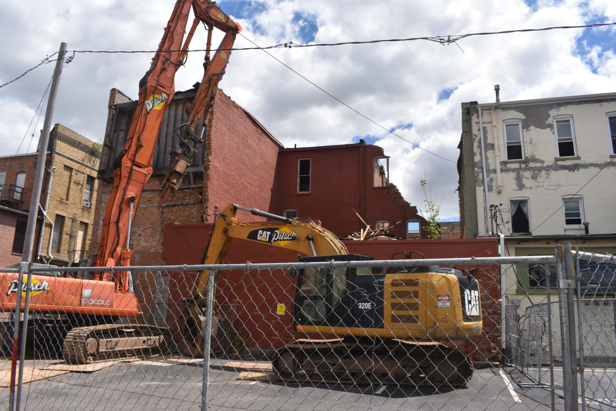 Machinery is pictured Friday within a fenced area in the South Winter Street parking lot in Adrian. The machinery is being used to demolish three South Main Street buildings that the city has deemed blighted.
