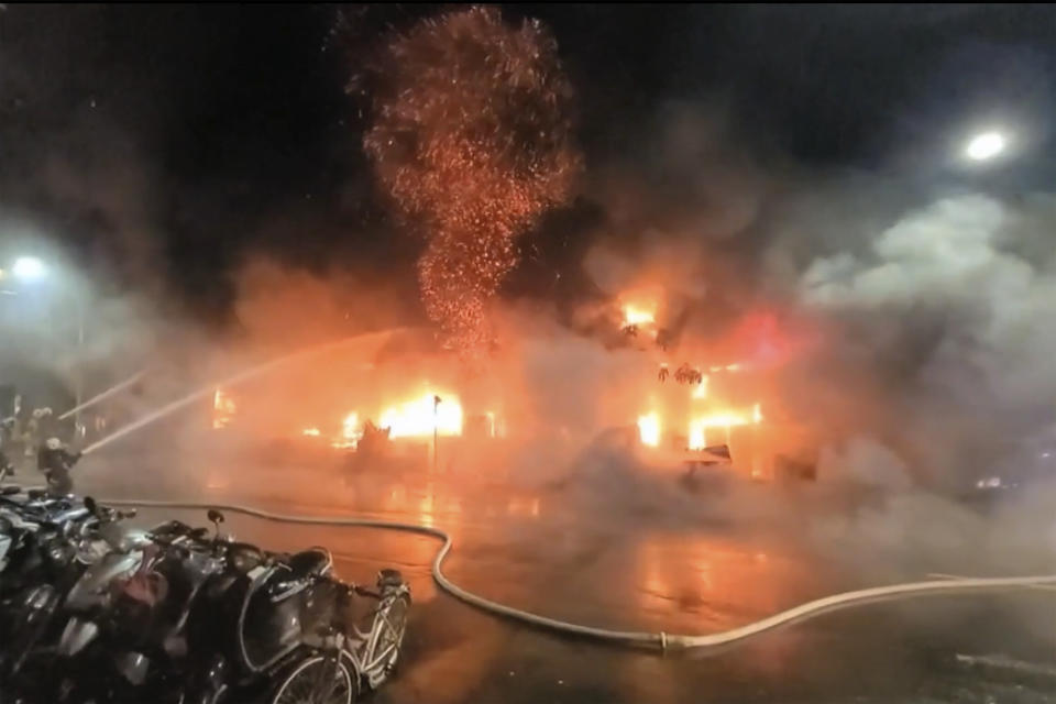 In this image taken from video by Taiwan's EBC, firefighters battle a blaze at a building in Kaohsiung, in southern Taiwan on Thursday, Oct. 14, 2021. A fire engulfed a 13-story building overnight in southern Taiwan, the island’s semi-official Central News Agency reported Thursday. (EBC via AP )