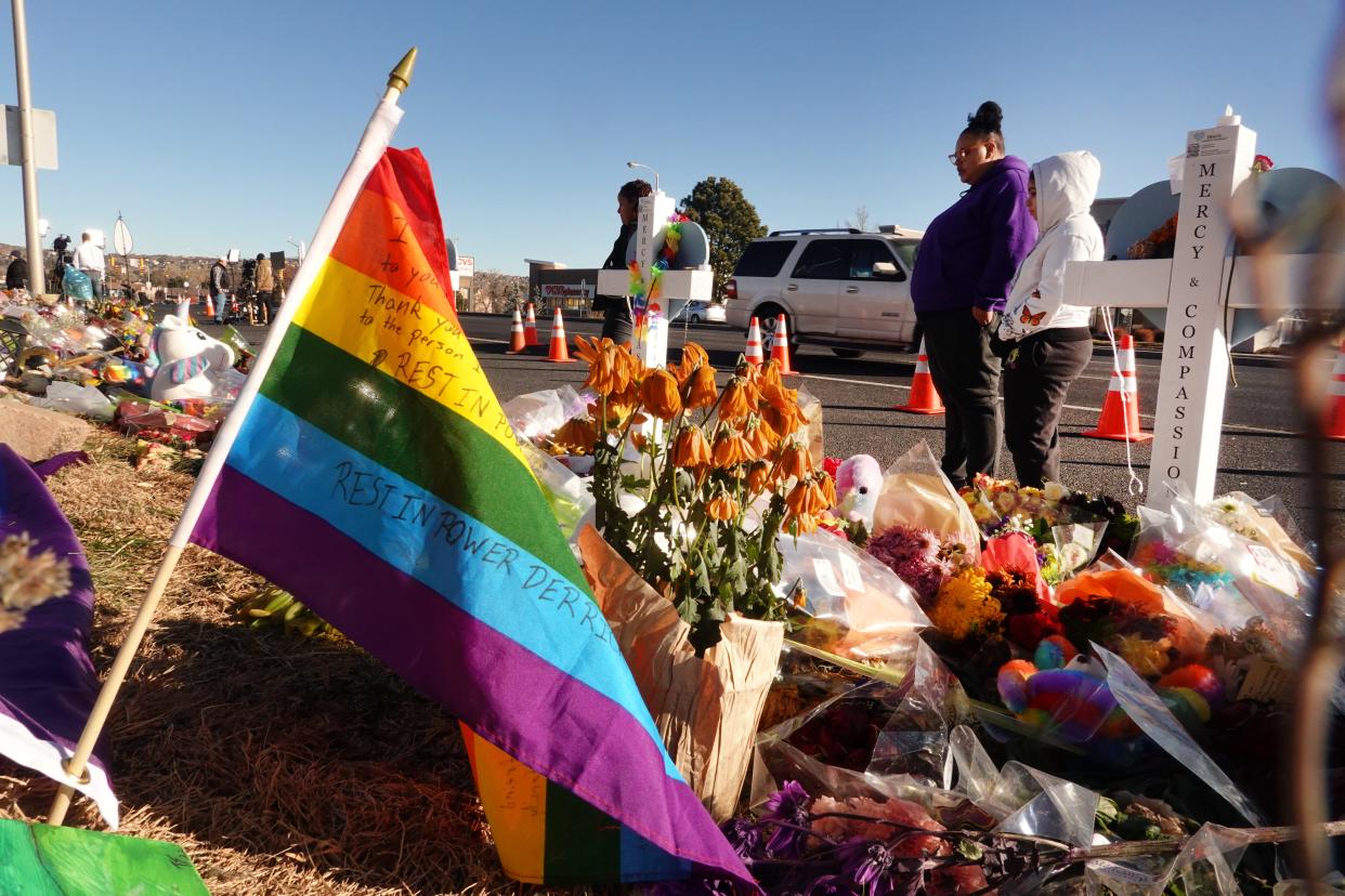 People are pictured visiting a makeshift memorial near the Club Q nightclub in Colorado Springs, Colorado.