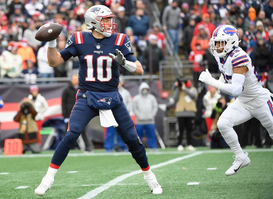 New England Patriots quarterback Mac Jones looks to throw as Buffalo Bills safety Michah Hyde closes in during the first half of a game against the Buffalo Bills at Gillette Stadium in Foxboro on Sunday, Dec. 26, 2021.