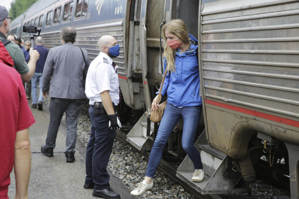 A passenger, right, gets off the Amtrak Vermonter passenger train after it arrived at the Montpelier station, in Berlin, Vt., Monday July 19, 2021. Celebrations were held at Amtrak stations across the state to mark the return of the passenger trains to Vermont for the first time since they were suspended at the beginning of the COVID-19 pandemic. (AP Photo/Wilson Ring)