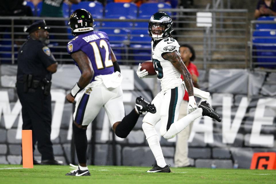 Philadelphia Eagles cornerback Eli Ricks, right, returns an interception for a touchdown thrown by Baltimore Ravens quarterback Anthony Brown Jr. (12) during the second half of a preseason game in Baltimore, Saturday, Aug. 12, 2023.