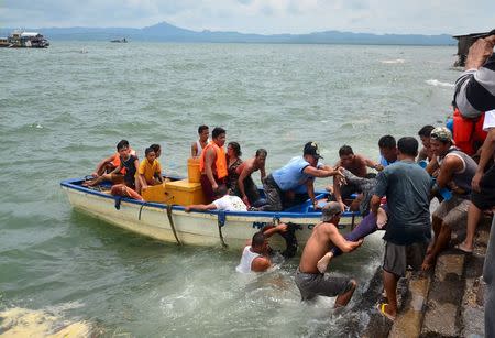 A body is carried by rescuers during a search and rescue operation following a ferry capsize in Ormoc city, central Philippines July 2, 2015. REUTERS/Ronald Frank Dejon