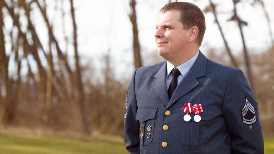 Shot of a high ranking military officer standing at ease in the outdoors.