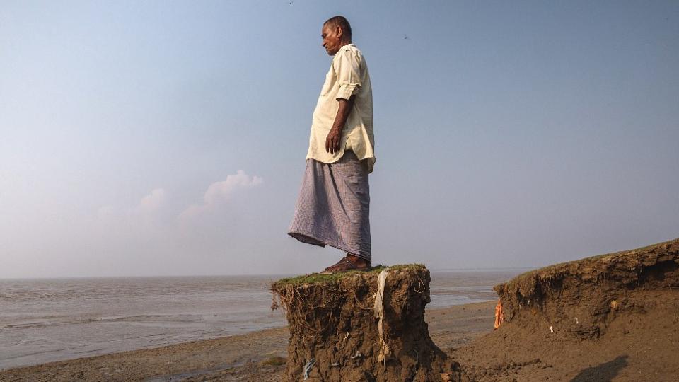 Shankar Kayal, residente de Sangar, parado en un pequeño montículo de tierra frente al mar. El resto el terreno colapsó con el avance del agua.