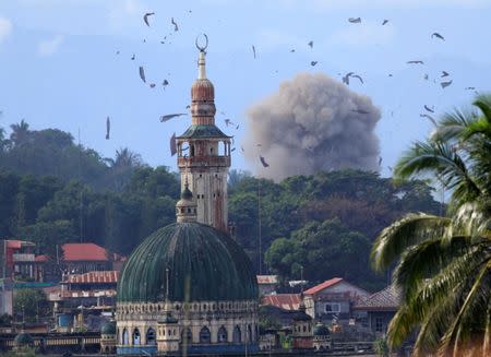 Debris and smoke are seen after an OV-10 Bronco aircraft released a bomb, during an airstrike, as government troops continue their assault against insurgents from the Maute group, who have taken over parts of Marawi city, Philippines. REUTERS/Romeo Ranoco
