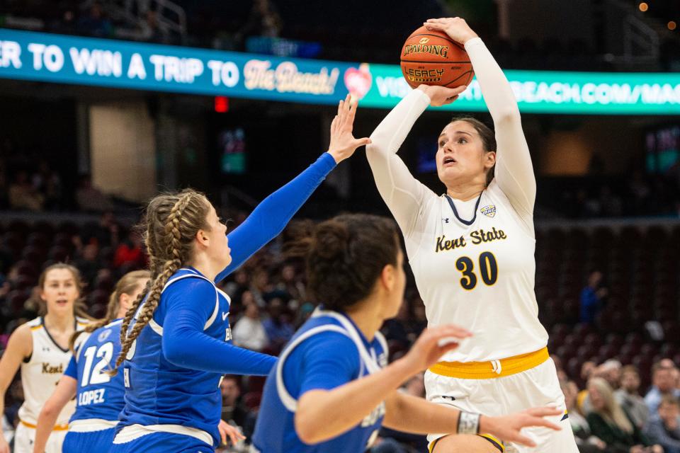 Kent State's Mikala Morris (30) shoots as Buffalo's Hattie Ogden (33) defends during the first half of an NCAA college game in the championship of the Mid-American Conference tournament, Saturday, March 16, 2024, in Cleveland. (AP Photo/Phil Long)