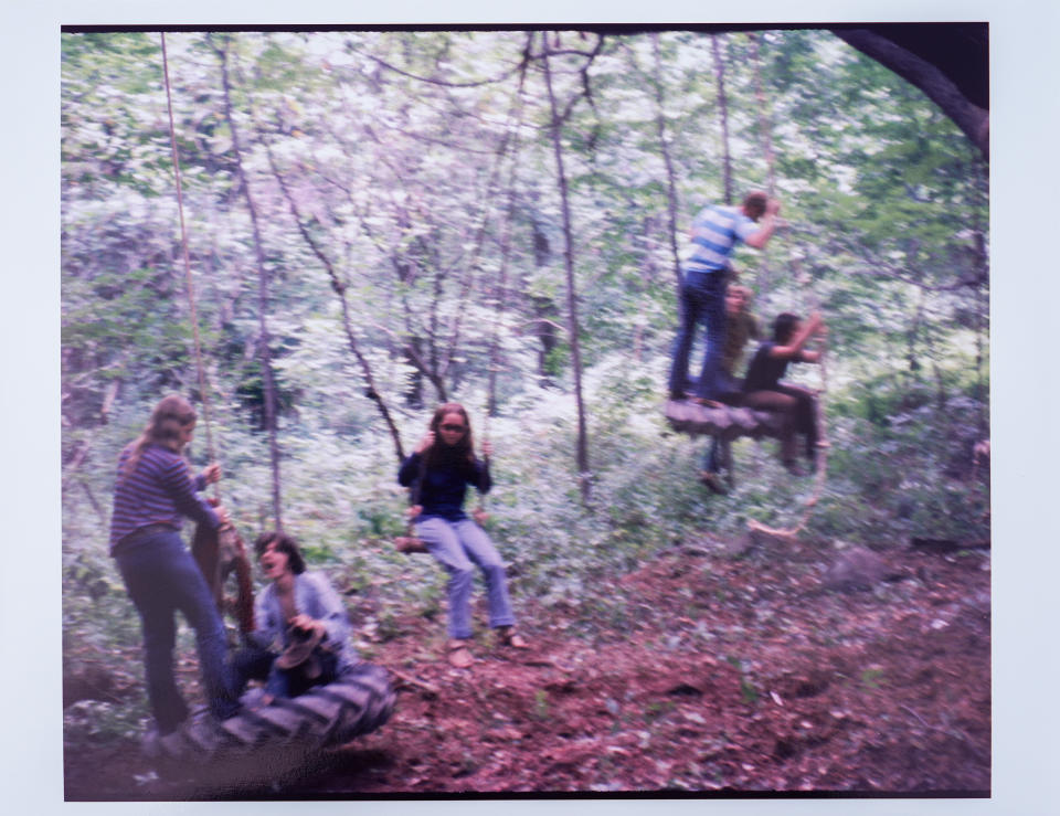 Esta fotografía de agosto de 1969 muestra a Ellen Shelburne, en el centro, en un columpio en los terrenos de la Feria de Arte y Música de Woodstock en Bethel, Nueva York. El Centro para las Artes Bethel Woods, la organización sin fines de lucro que administra el sitio, desenrolló la alfombra teñida de colores para Shelburne y su amiga, Beverly Grant (que no aparece en la foto) para promocionar sus nuevas instalaciones de campamento de lujo y revisar el tesoro de fotografías de Shelburne del festival que definió a una generación, celebrado del 15 al 18 de agosto de 1969. (David Shelburne via AP)