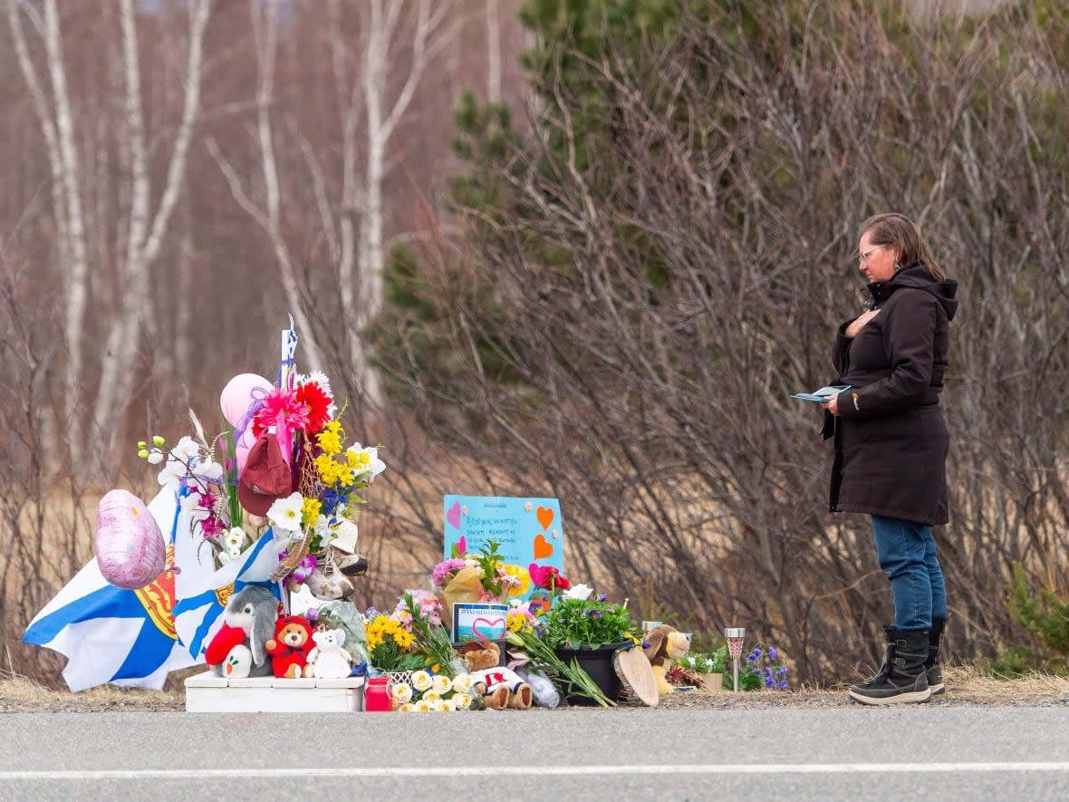 A mourner stops to pay her respects at a roadside memorial for one of the victims of the mass shooting, in Wentworth, N.S., on April 24, 2020. (Liam Hennessey/The Canadian Press - image credit)