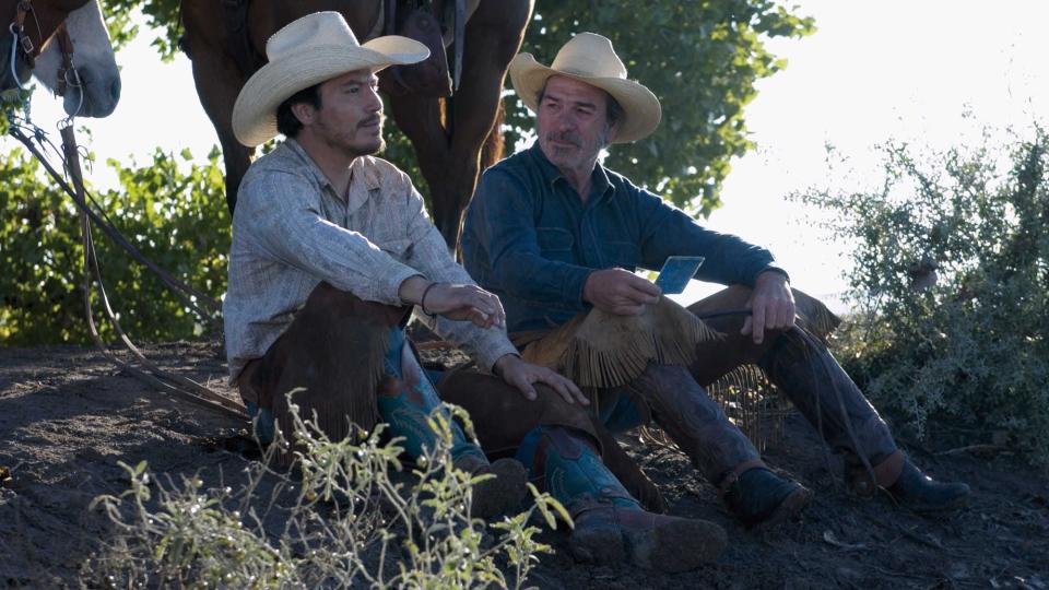 Julio Cesar Cedillo and Tommy Lee Jones sitting by horses