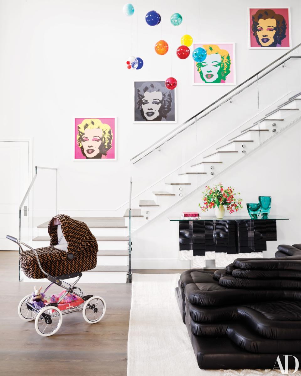 Andy Warhol screen prints ascend with the stairwell in the home’s entry. Fendi stroller by Inglesina.