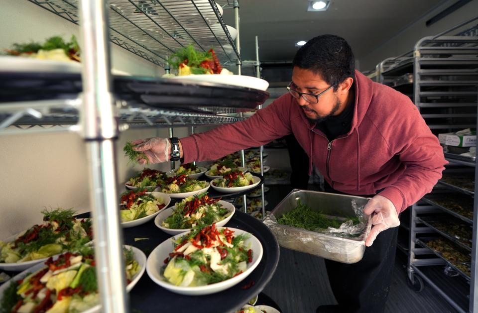 Paris Pulido preps the salads inside a refrigerated truck during an ASU event catered by Atlasta Catering.