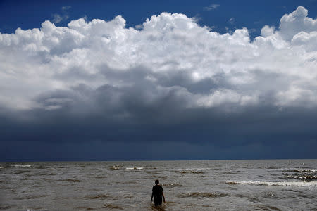 15-year-old Jordan Carambat wades in the ocean as Tropical Storm Gordon approaches Waveland, Mississippi, U.S., September 4, 2018. REUTERS/Jonathan Bachman