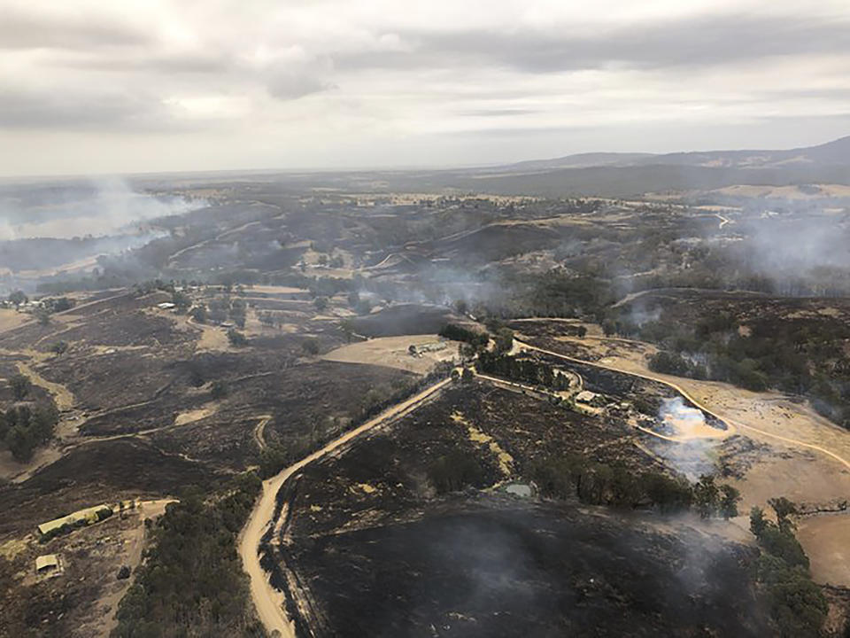 In this Monday, Dec. 30, 2019, aerial photo, acres of scorched land are seen in Bairnsdale, Australia. Thousands of tourists fled Australia's wildfire-ravaged eastern coast Thursday ahead of worsening conditions as the military started to evacuate people trapped on the shore further south. (Glen Morey via AP)