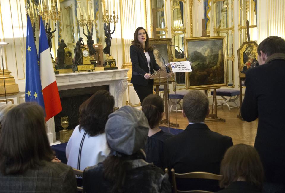 France’s culture minister Aurelie Filipetti, speaks during a ceremony to return three paintings taken from their owners during World War II at the Culture Ministry in Paris, Tuesday, March 11, 2014. The restitution is part of France's ongoing effort to return hundreds of looted artworks that Jewish owners lost during the war that still hang in the Louvre and other museums. (AP Photo/Michel Euler)