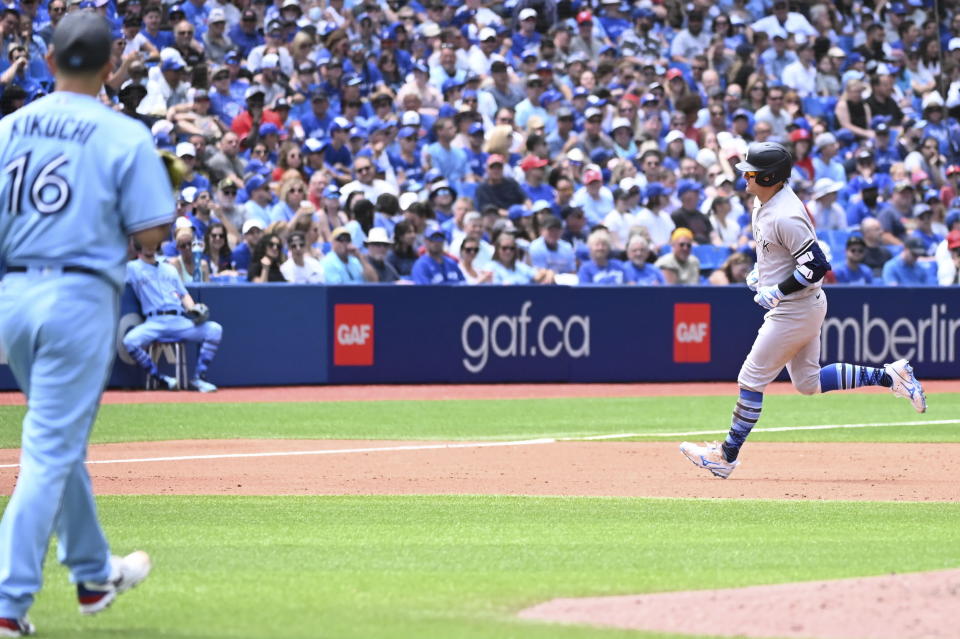 New York Yankees' Josh Donaldson, right, runs the bases after hitting a two-run home run, also scoring Joey Gallo, off Toronto Blue Jays starting pitcher Yusei Kikuchi, left, in third-inning baseball game action in Toronto, Sunday, June 19, 2022. (Jon Blacker/The Canadian Press via AP)