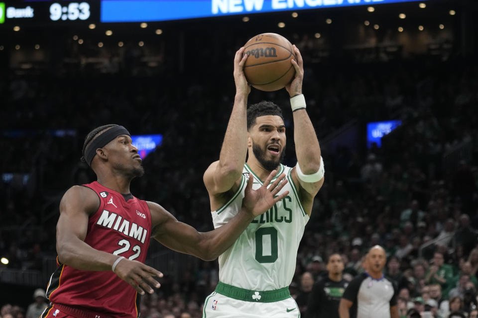 Boston Celtics forward Jayson Tatum (0) battles with Miami Heat forward Jimmy Butler (22) in the second half of Game 1 of the NBA basketball Eastern Conference finals playoff series in Boston, Wednesday, May 17, 2023. (AP Photo/Charles Krupa)