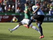 Alvaro Pereira (R) of Uruguay kicks the ball past Juan Zampiery of Bolivia during their 2018 World Cup qualifying soccer match at the Hernando Siles Stadium in La Paz, Bolivia, October 8, 2015. REUTERS/David Mercado