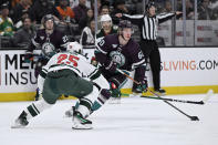 Anaheim Ducks defenseman Jackson LaCombe (60) controls the puck with Minnesota Wild defenseman Jonas Brodin (25) defending during the first period of an NHL hockey game in Anaheim, Calif., Tuesday, March 19, 2024. (AP Photo/Alex Gallardo)