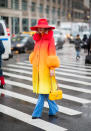 <p>A guest wearing an ombre coat, red hat and blue trousers during New York Fashion Week. <em>[Photo: Getty]</em> </p>