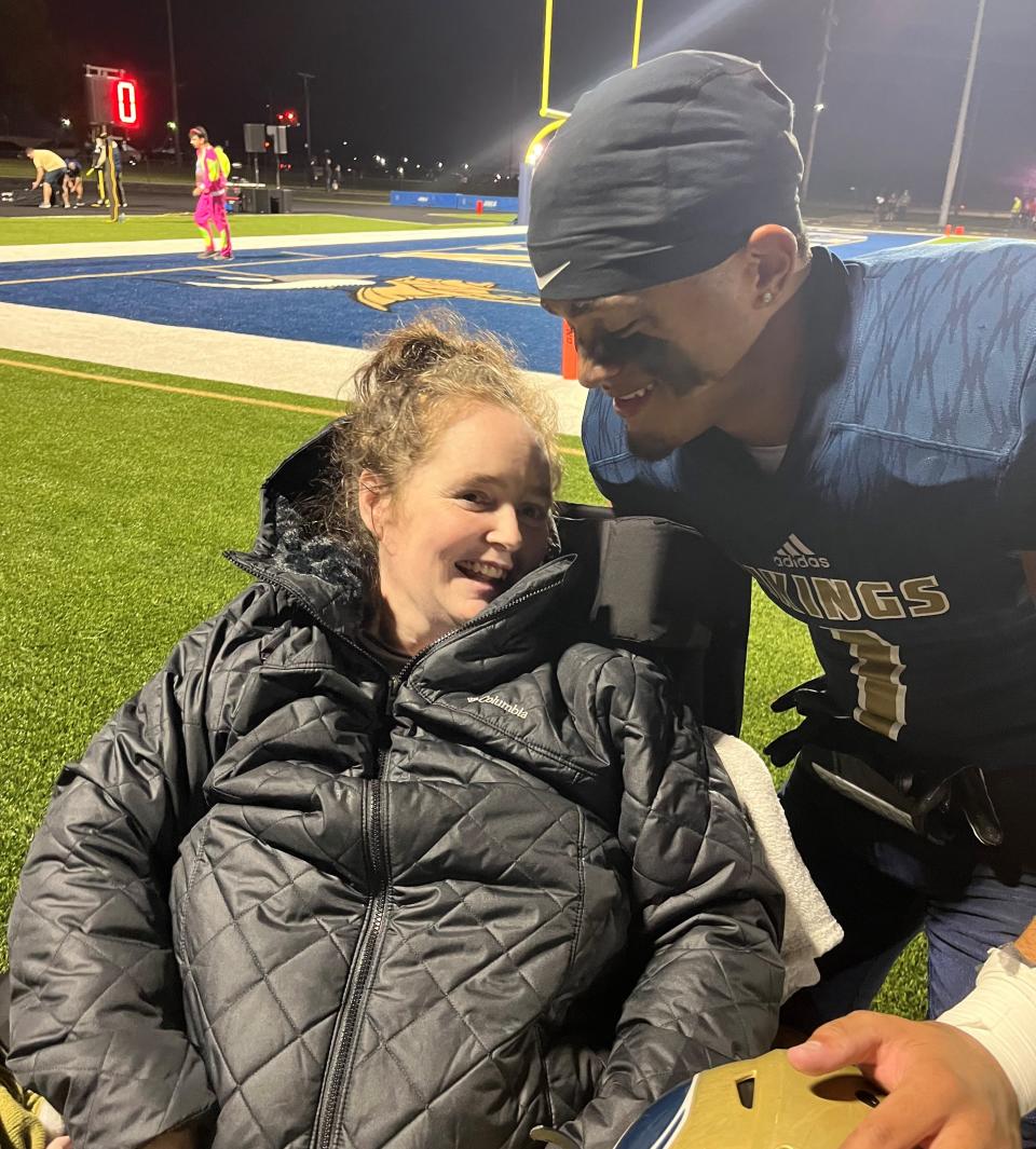 Niles senior Julian Means-Flewellen, right, takes a picture with his mother, Jennifer Flewellen, after a Niles football game on Oct. 6, 2023, at Niles High School.