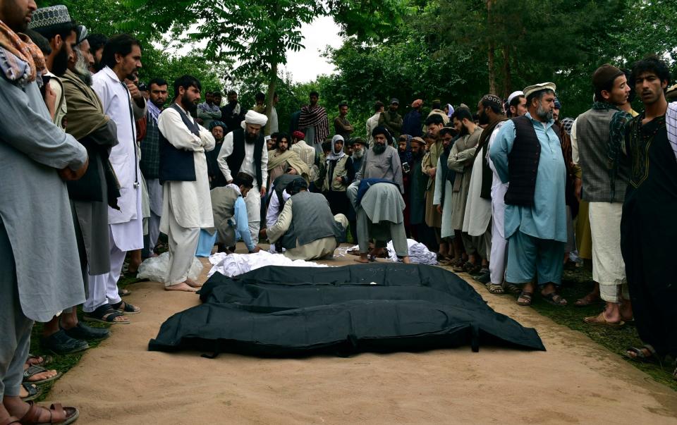 Dead bodies are placed on the ground after heavy flooding in Baghlan province