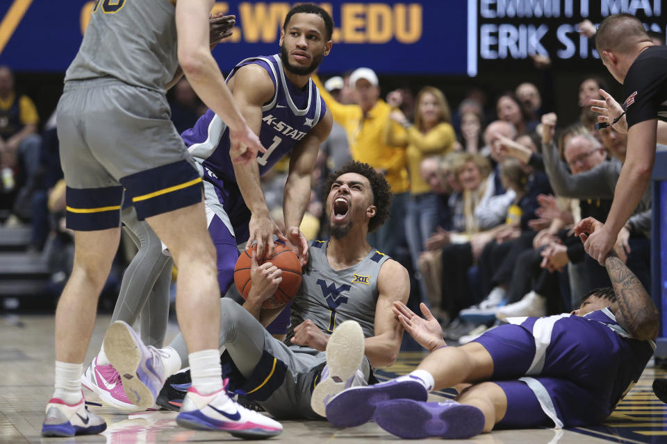 West Virginia forward Emmitt Matthews Jr. (1) reacts while defended by Kansas State guard Markquis Nowell (1) during the first half of an NCAA college basketball game on Saturday, March 4, 2023, in Morgantown, W.Va. (AP Photo/Kathleen Batten)