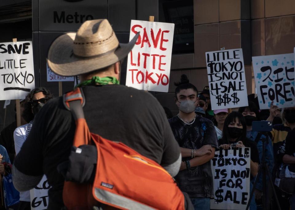 People hold up signs outdoors.