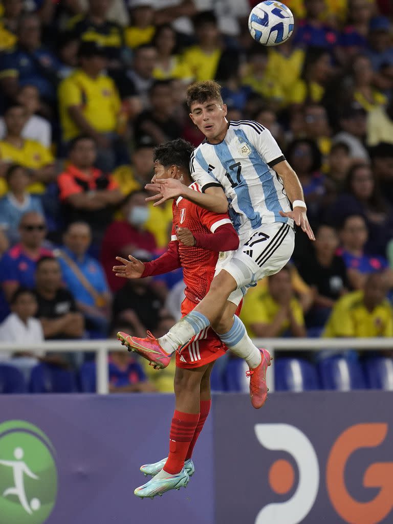 Ulises Ciccioli y Diether Vásquez pujan en el aire por la pelota; al defensor lateral argentino le cometieron la falta que derivó en el tiro libre que propició el gol de Infantino.