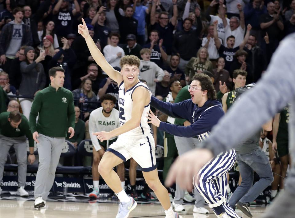 A Utah State fan runs onto the court to celebrate the Aggies’ win over No. 13 Colorado State with freshman guard Mason Falslev Jan. 6, at the Spectrum in Logan. | Jeff Hunter