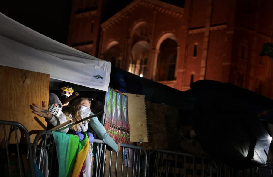 LOS ANGELES, CALIFORNIA – May 1: Pro-Palestinian protestors protect themselves from pro-Israeli supporters next at an the encampment at UCLA early Wednesday morning. (Wally Skalij/Los Angeles Times via Getty Images)