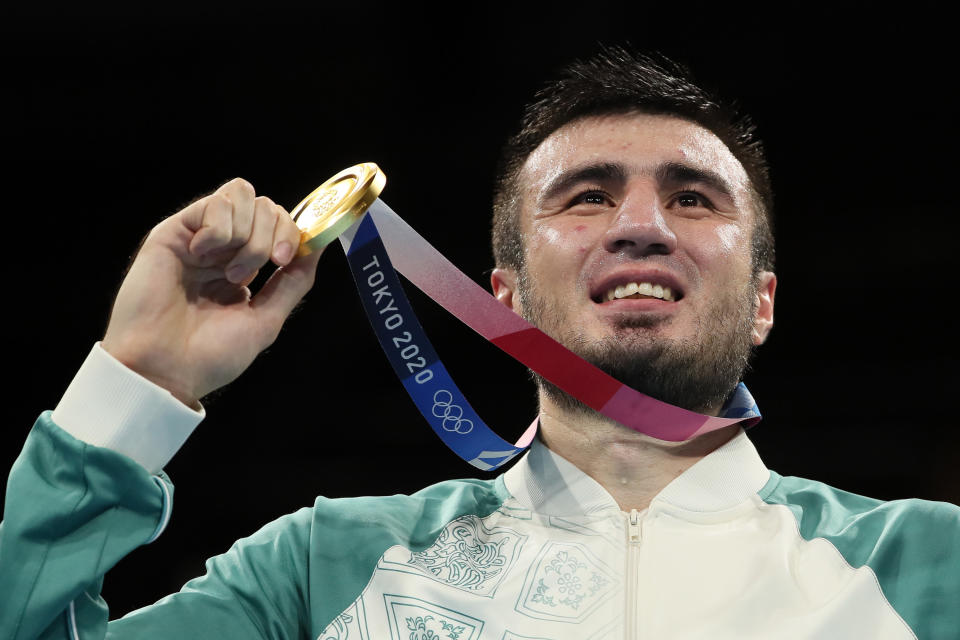 Bakhodir Jalolov of Uzbekistan holds gold medal up