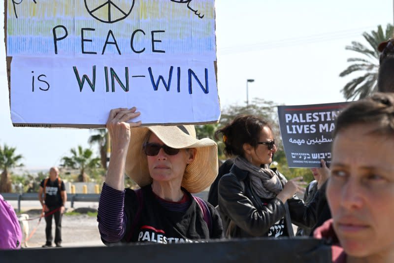 Israelis and Palestinians holds placards and banners with messages calling for a cease-fire and end of the war in Gaza at a protest at the Almog Junction near Jericho in the West Bank on Friday. Photo by Debbie Hill/UPI