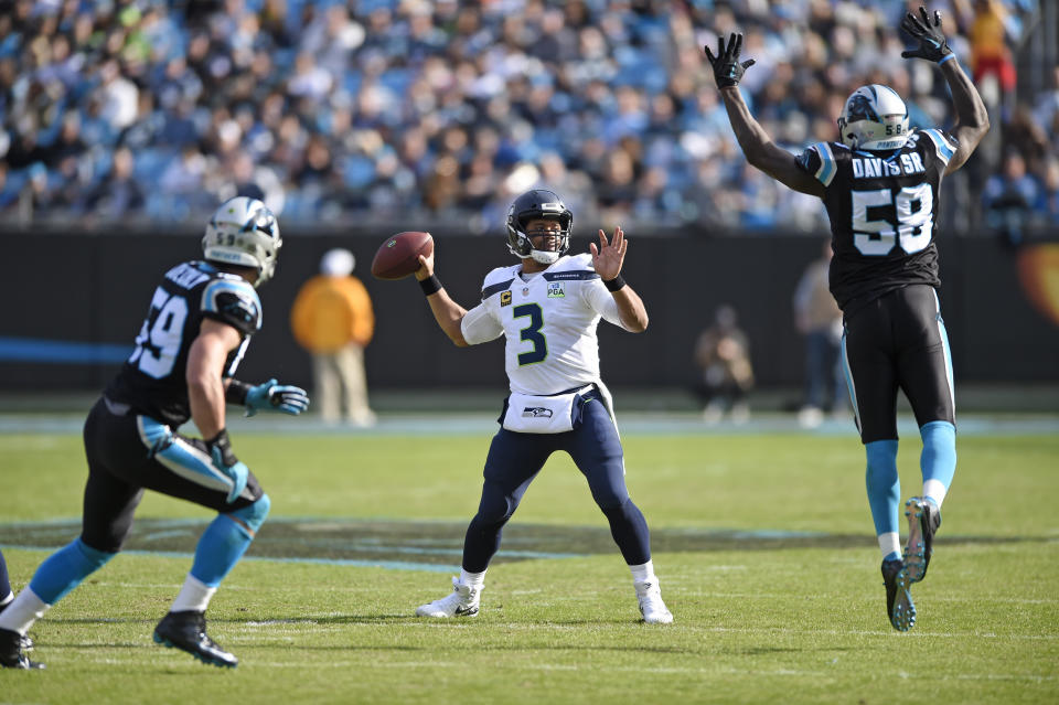 Seattle Seahawks' Russell Wilson (3) tries to pass over Carolina Panthers' Thomas Davis (58) during the first half of an NFL football game in Charlotte, N.C., Sunday, Nov. 25, 2018. (AP Photo/Mike McCarn)
