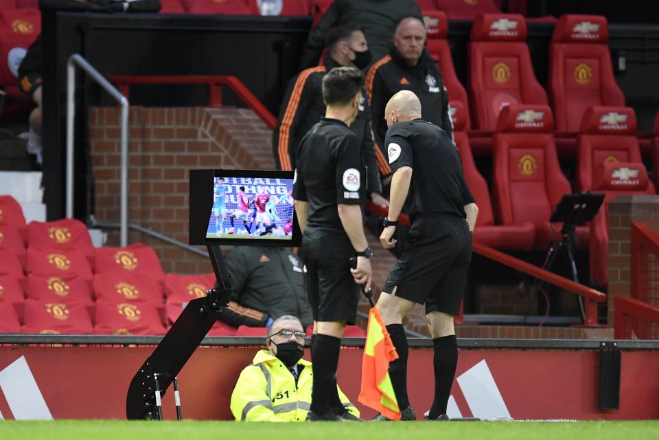 Referee Anthony Taylor consults a monitor before overturning a penalty decision in a Premier League match between Manchester United and Liverpool (Peter Powell/PA) (PA Wire)