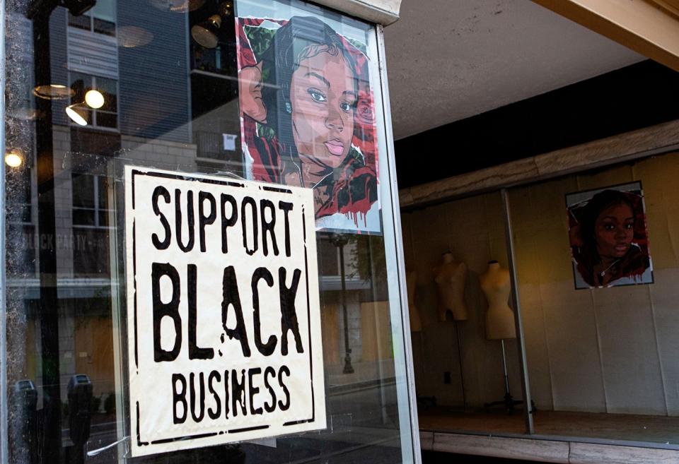 A portrait of Breonna Taylor is seen in the front window of a downtown Louisville business.