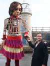 <p>Jude Law poses with 'Little Amal' a puppet of a young Syrian refugee girl as she arrives in Folkstone, Britain on Oct. 19. </p>