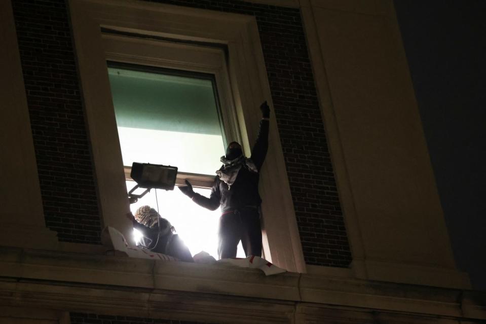 Protesters in a window of Hamilton Hall. REUTERS