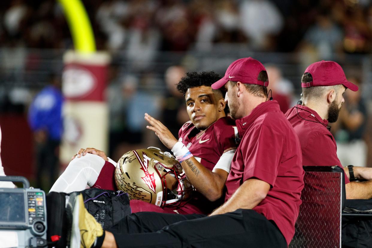 Nov 18, 2023; Tallahassee, Florida, USA; Florida State Seminoles quarterback Jordan Travis (13) waves to fans while being carted off after an injury against the North Alabama Lions during the first quarter at Doak S. Campbell Stadium. Mandatory Credit: Morgan Tencza-USA TODAY Sports