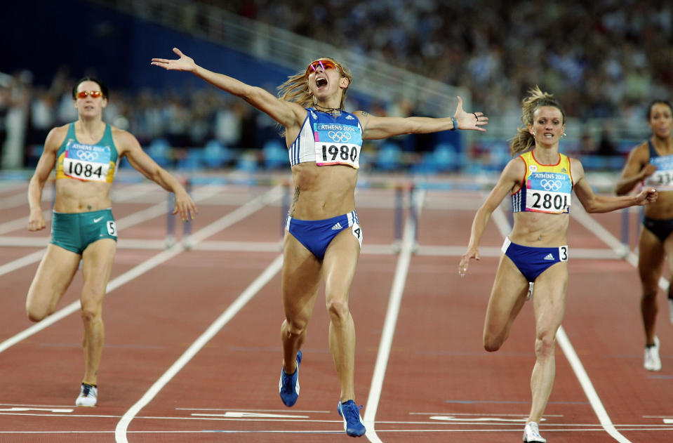 ATHENS - AUGUST 25: Fani Halkia of Greece crosses the finish line in first place in the women's 400 metre hurdle final, with Jana Pittman (left) of Australia finishing fifth and Ionela Tirlea-Manolache (r) of Romania finishing second on August 25, 2004 during the Athens 2004 Summer Olympic Games at the Olympic Stadium in the Sports Complex in Athens, Greece. (Photo by Stuart Hannagan/Getty Images)