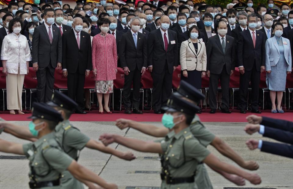 Hong Kong Chief Executive Carrie Lam, fourth from left in front, and former Chief Executives Tung Chee-hwa, third from left, and Leung Chun-ying, second from left, attend the flag raising ceremony at the Golden Bauhinia Square to mark the 71st anniversary of Chinese National day in Hong Kong Thursday, Oct. 1, 2020. Others are, Chief Justice Geoffrey Ma, sixth from left, and Lam's husband Lam Siu-por at fifth from left. (AP Photo/Vincent Yu)