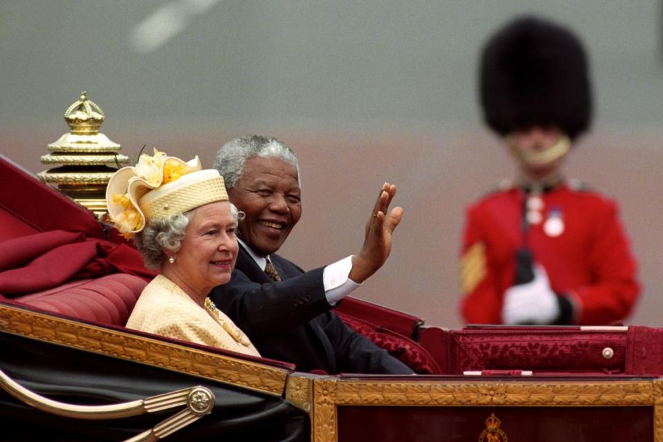 <p>Nelson Mandela, President of South Africa, rides alongside The Queen in a carriage along the Mall on the first day of his state visit to Britain. (PA Archive) </p>