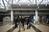 People walk under a banner promoting the postponed Tokyo 2020 Olympic and Paralympic Games at the Tokyo International Exhibition Center, in Tokyo Thursday, April 8, 2021. The exhibition center, also known as Tokyo Big Sight, is a planned venue for the Tokyo 2020, rescheduled to start in July 2021. Many preparations are still up in the air as organizers try to figure out how to hold the postponed games in the middle of a pandemic. (AP Photo/Hiro Komae)