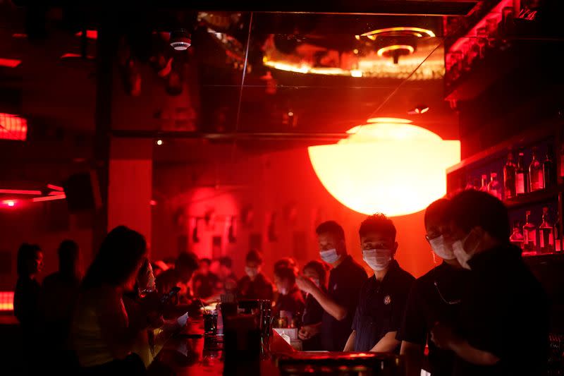 People wear face masks at a nightclub after it reopens in Shanghai