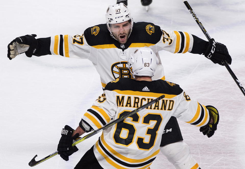 FILE - Boston Bruins' Brad Marchand (63) celebrates with teammate Patrice Bergeron after scoring against the Montreal Canadiens during the shootout in NHL hockey action in Montreal, Saturday, Jan. 13, 2018. Bruins forward Patrice Bergeron has retired. The five-time Selke Trophy winner announced Tuesday, July 25, 2023, that he will not return for a 20th season with the only team he has ever played for. The Bruins captain said he is leaving with no regrets.(Graham Hughes/The Canadian Press via AP, File)
