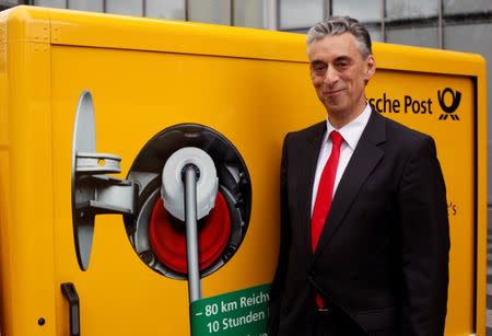 Frank Appel, CEO of German postal and logistics group Deutsche Post (DHL) poses in front of a StreetScooter E-car in Bonn May 21, 2013. REUTERS/Wolfgang Rattay/File Photo