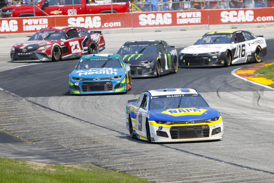 Chase Elliott (9) leads a group through a turn during a NASCAR Cup Series auto race Sunday, July 4, 2021, at Road America in Elkhart Lake, Wis. (AP Photo/Jeffrey Phelps)