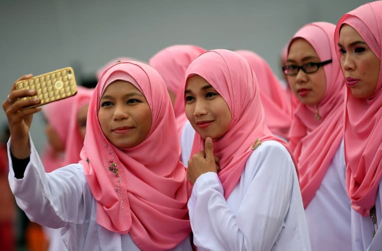 Members of the ruling party United Malays National Organisation pose for photographs before the opening ceremony of the party's annual congress in Kuala Lumpur