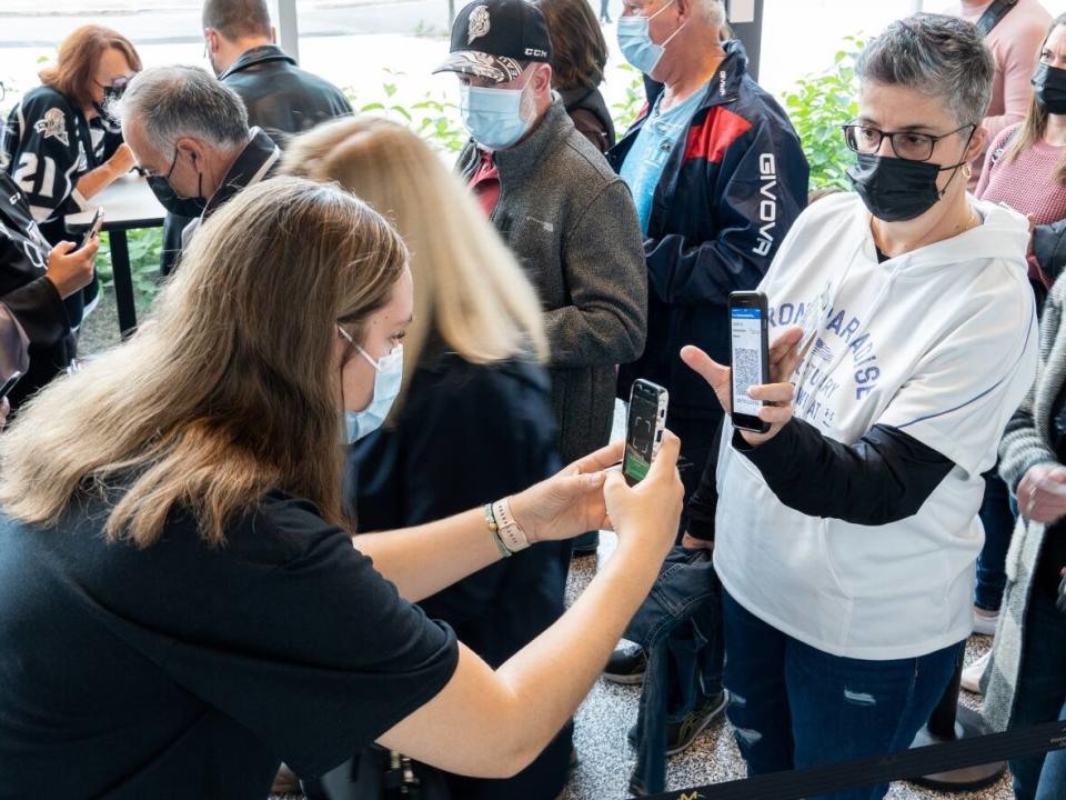 People show proof they've been fully vaccinated against COVID-19 as they enter the Centre Slush Puppie in Gatineau, Que. (Alexander Behne/CBC - image credit)