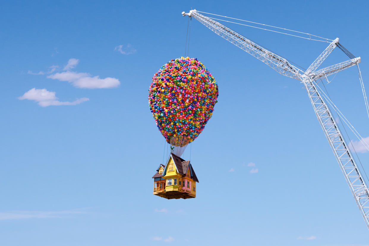 Airbnb's "Up" house, with 8,000 balloons, is held up by a crane.